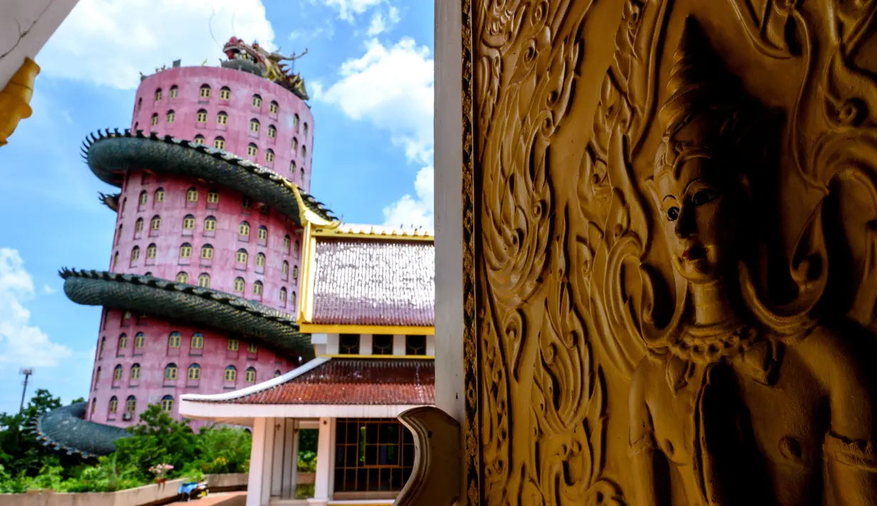 Menara dengan naga raksasa terlihat di kuil Buddha Wat Samphran (Kuil Naga) di Nakhon Pathom, sekitar 40 km sebelah barat Bangkok pada 11 September 2020. Kuil dengan 17 lantai itu berwujud sebuah menara berwarna merah muda yang dililit oleh naga hijau bersisik. (Photo by Mladen ANTONOV / AFP)