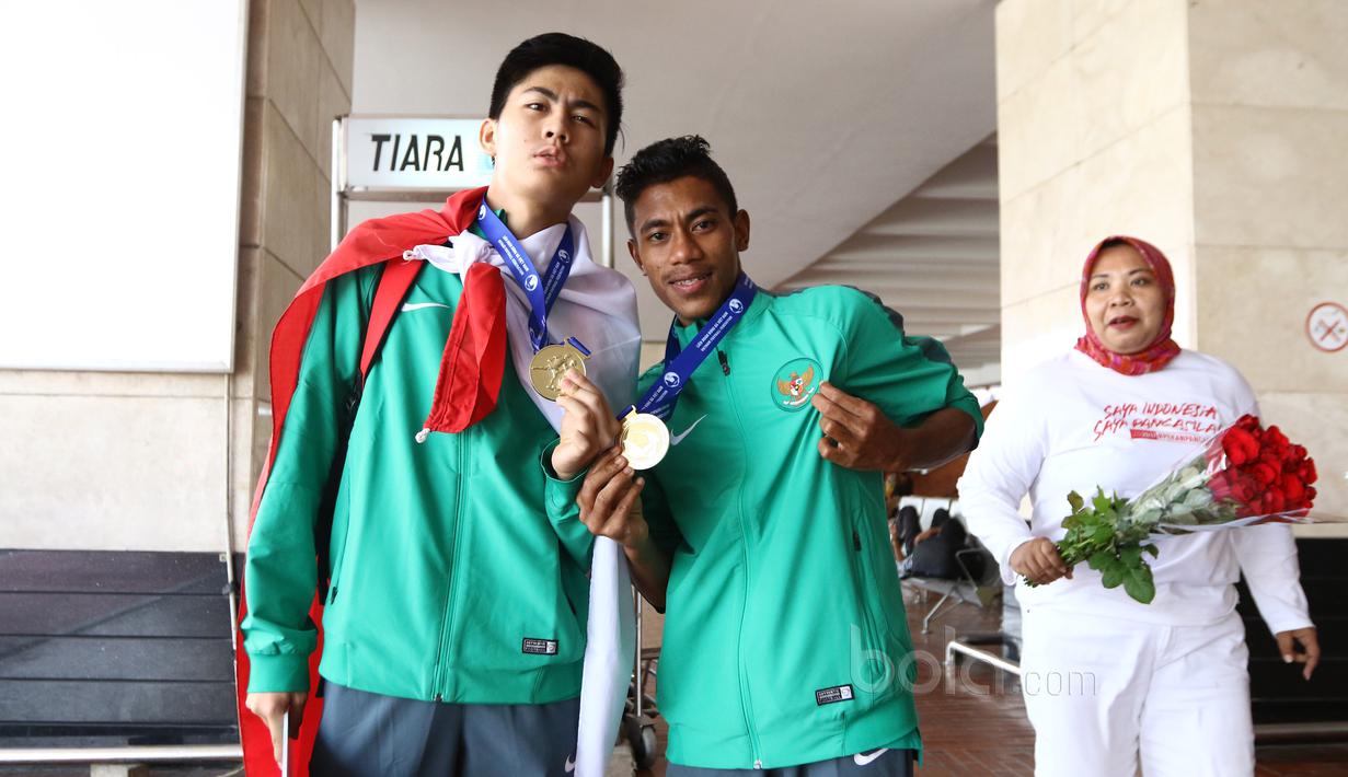 Dua pemain Timnas Indonesia U-16, Rendy Juliansyah dan Hamsah Lestaluhu berfoto saat tiba di Bandara Soekarno-Hatta, Cengkareng, Senin (19/6/2017). Timnas U-16 meraih juara pada ajang Tien Phong Plastic Tournament 2017. (Bola.com/Nicklas Hanoatubun)