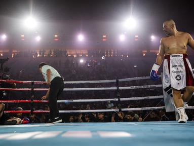Chef Arnold (kiri) terkapar setelah menerima pukulan dari konten kreator, Codeblue (kanan) dalam pertarungan tinju Holywings Sports Show (HSS) seri kelima di Indonesia Arena, Kompleks Stadion Utama Gelora Bung Karno, Senayan, pada Minggu (22/04/2024). (Bola.com/Bagaskara Lazuardi)