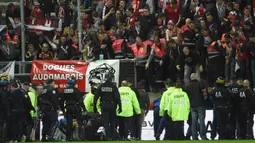 Petugas keamanan membatu suporter yang terjatuh dari tribun saat Amiens melawan Lille LOSC  di Licorne stadium, Amiens, (30/9/2017). Laga tersebut akhirnya ditunda. (AFP/Francois Lo Presti)