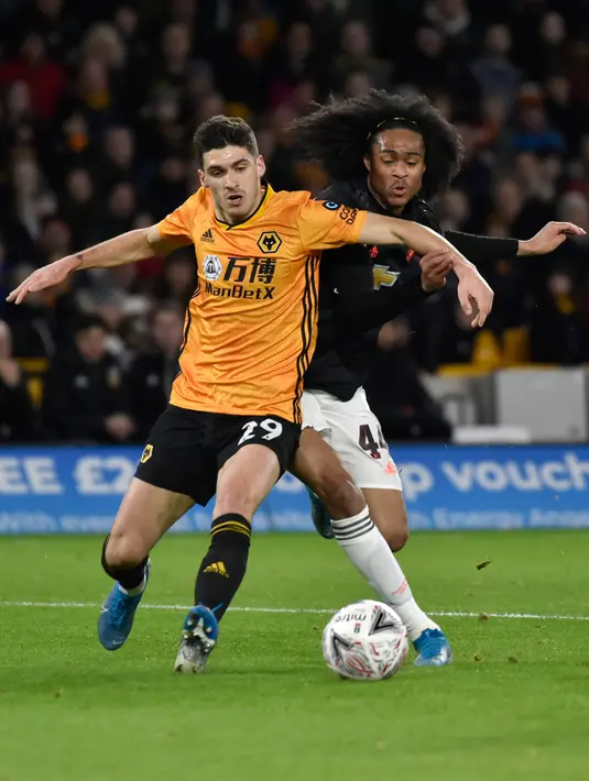 Penyerang  muda Manchester United, Tahith Chong berebut bola dengan pemain Wolverhampton Wanderers, Rubver Vinagre pada babak ketiga Piala FA di Molineux, Sabtu (4/1/2020). Wolverhampton dan MU dipaksa untuk melakukan laga ulangan di Old Trafford setelah bermain imbang tanpa gol. (AP/Rui Vieira)