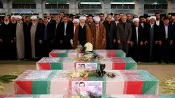 Warga Iran menggelar salat jenazah untuk 16 petugas pemadam kebakaran yang tewas dalam runtuhnya gedung yang terbakar pada 19 Januari, di Teheran, Iran, Senin (30/1). (AP Photo / Ebrahim Noroozi)
