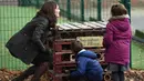 Kate Middleton saat bermain dengan anak-anak Sekolah Dasar Robin Hood di London, Inggris (29/11). Middleton tampil cantik mengenakan jaket berwarna cokelat dengan rambut terurai. (AFP Photo/Pool/Eddie Mulholland)