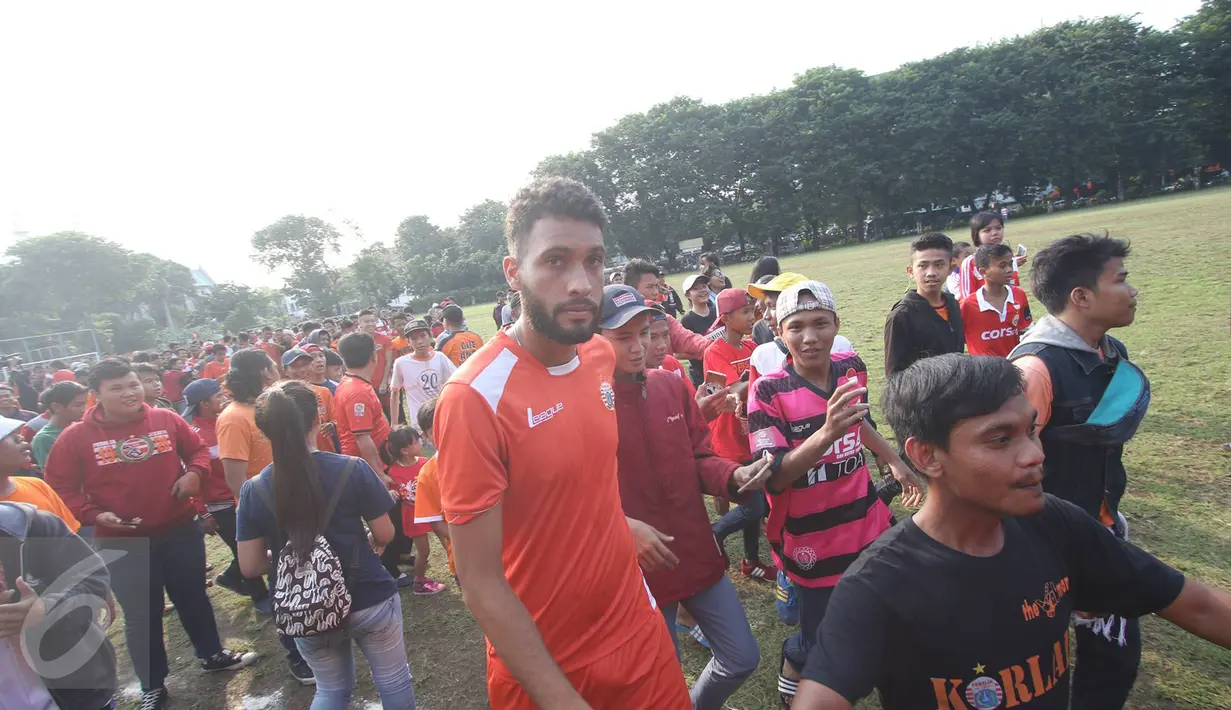 Pemain klub Persija Jakarta dikerumuni pendukung The Jakmania usai melakukan latihan di Lapangan Banteng, Jakarta, Selasa (11/4). Ratusan The Jakmania datang untuk menonton dan menyapa para pemain. (Liputan6.com/Immanuel Antonius)
