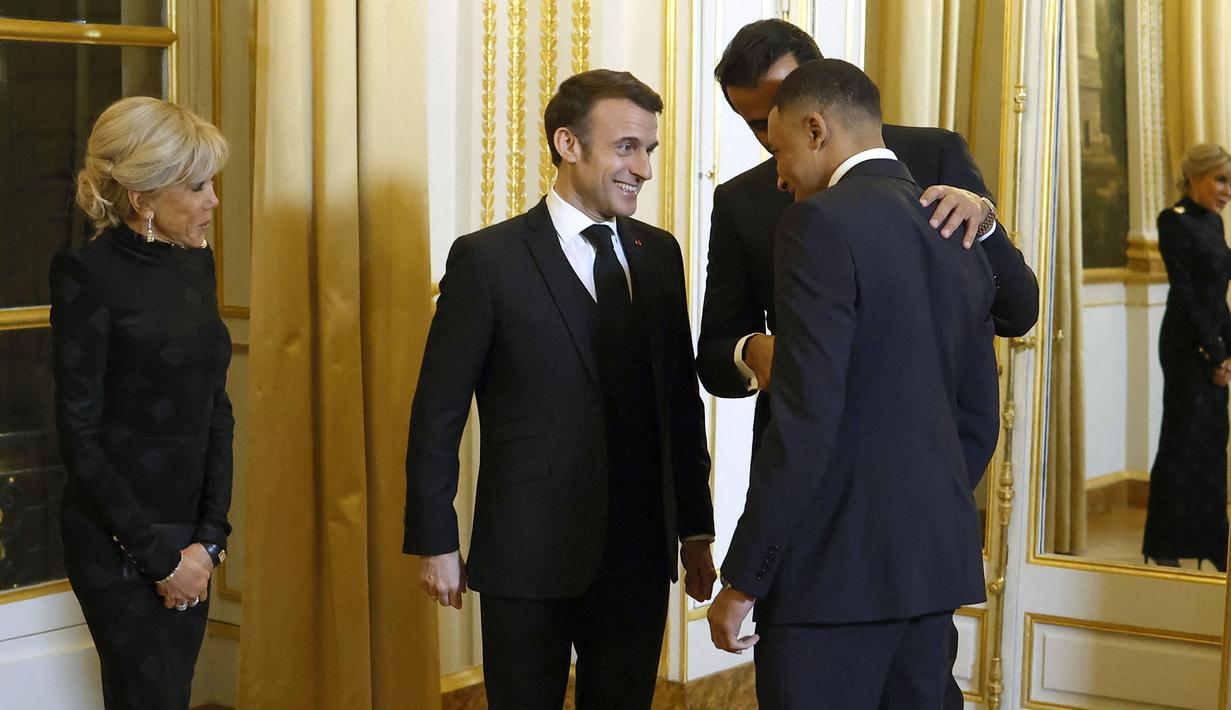 Pemain PSG, Kylian Mbappe (kanan) berbincang dengan Presiden Prancis, Emmanuel Macron (tengah) dan Emir Qatar, Sheikh Tamin bin Hamad Al-Thani (kedua kanan) saat diundang menjadi salah satu tamu di Istana Elysee, Prancis, Selasa (27/2) malam waktu setempat. (AFP/Pool/Yoan Valat)