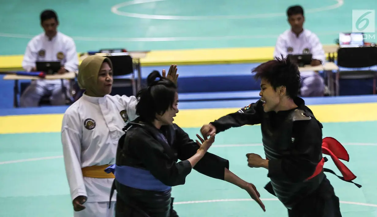 Pesilat Nirmalasari Oktaviani (kanan) beradu jurus dengan pesilat Laos Olathai Sounthavong di semifinal 50-55 kg putri cabang Pencak Silat 18th Asian Games Invitation Tournament, Jakarta, Senin (12/2). Indonesia menang 5-0. (Liputan6.com/Faizal Fanani)