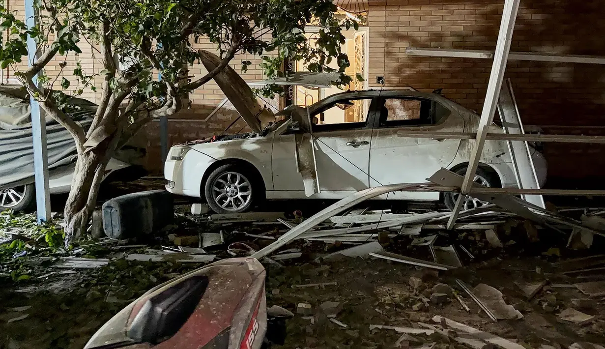 Puing-puing berserakan di sekitar sebuah mobil di lokasi yang menurut media Iran merupakan serangan AS di Kuhestak, Iran selatan,  Rabu dini hari, 2 September 2026. (Masoud Mohammadi/Tasnim News Agency via AP)