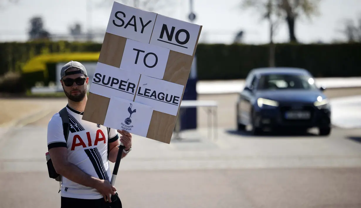Seorang penggemar Tottenham Hotspurs memegang spanduk anti Liga Super Eropa di luar tempat latihan, London, Senin (19/4/2021). (Foto: AFP/Tolga Akmen)