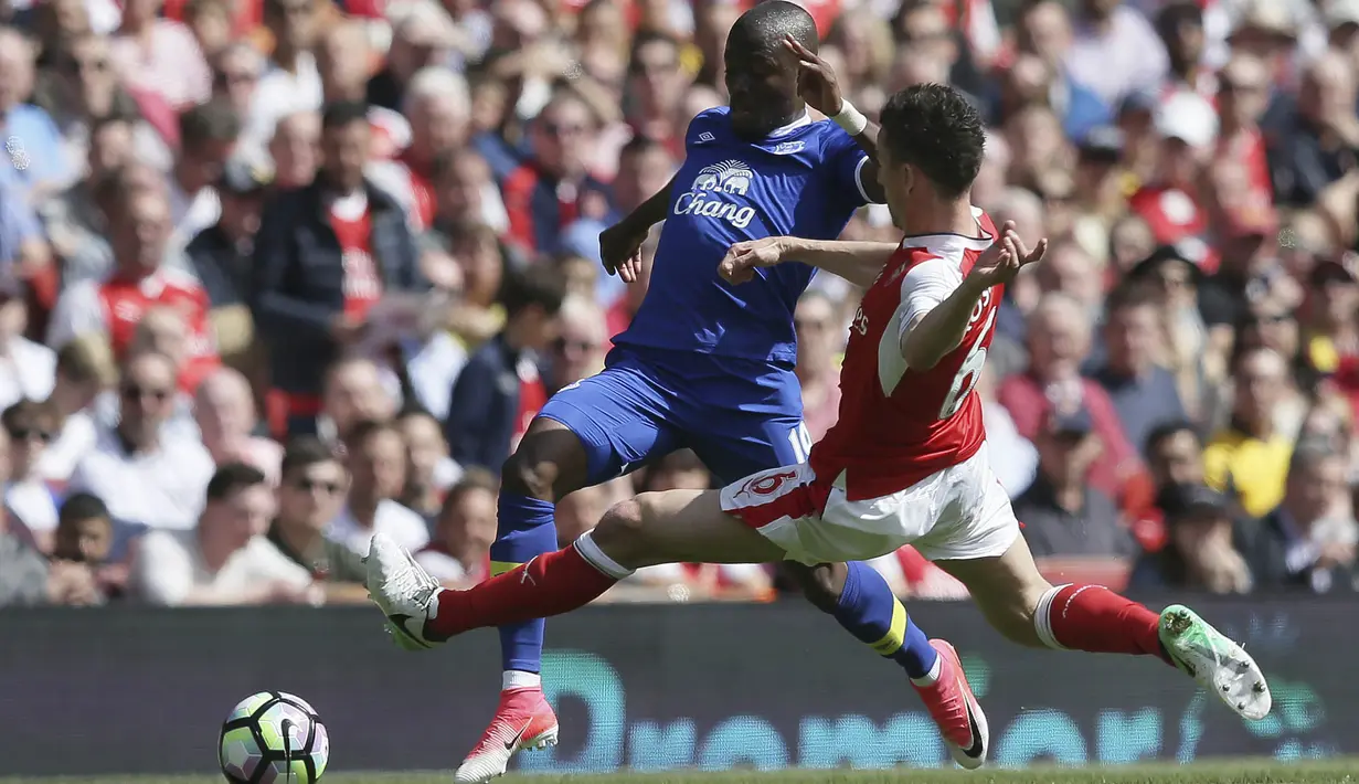 Bek Arsenal, Laurent Koscielny, menghadang striker Everton, Enner Valencia pada laga Premier League, di Stadion Emirates, Minggu (21/5/2017).  Arsenal menang 3-1. (AP/Tim Ireland)