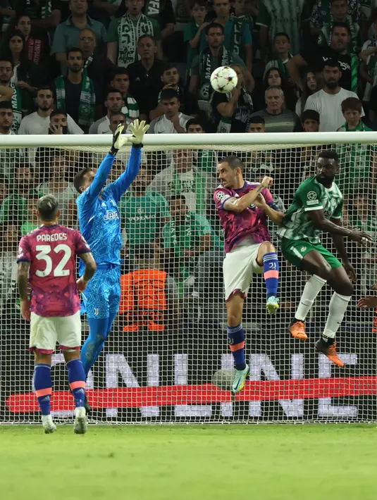 Kiper Juventus, Wojciech Szczesny (kedua-kiri) melompat berusaha menangkap bola saat bertanding melawan Maccabi Haifa selama pertandingan lanjutan grup H Liga Champions di stadion Sammy Ofer di kota Haifa pada 11 Oktober 2022. Maccabi Haifa menang atas Juventus 2-0. (AFP/JACK GUEZ)