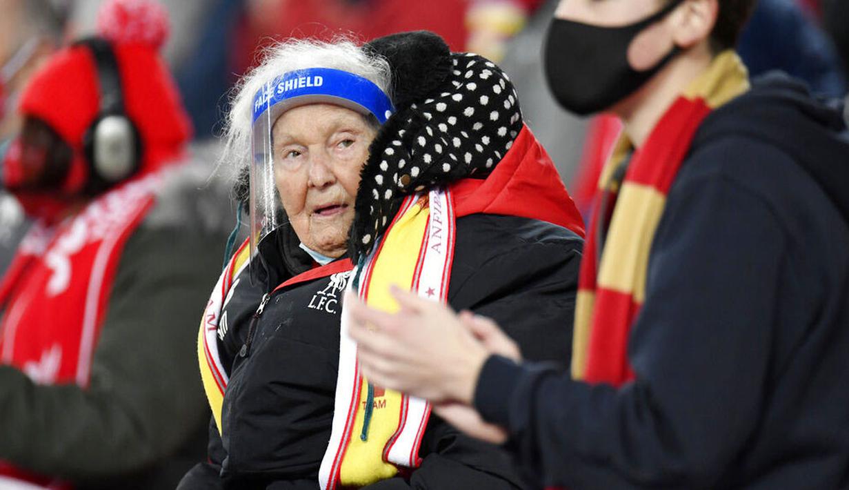 GUNAKAN PELINDUNG WAJAH DI STADION: Seorang suporter menggunakan pelindung wajah saat menyaksikan pertandingan antara Liverpool kontra Wolverhampton Wanderers  pada laga Liga Inggris di Stadion Anfield, Minggu (6/12/2020). (Peter Powell/Pool via AP)