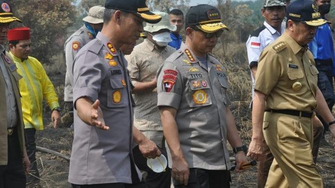 Kapolres Pelalawan AKBP Kaswandi Irawan menjelaskan situasi kebakaran lahan ke Kapolri Jenderal Tito Karnavian. (Liputan6.com/M Syukur)