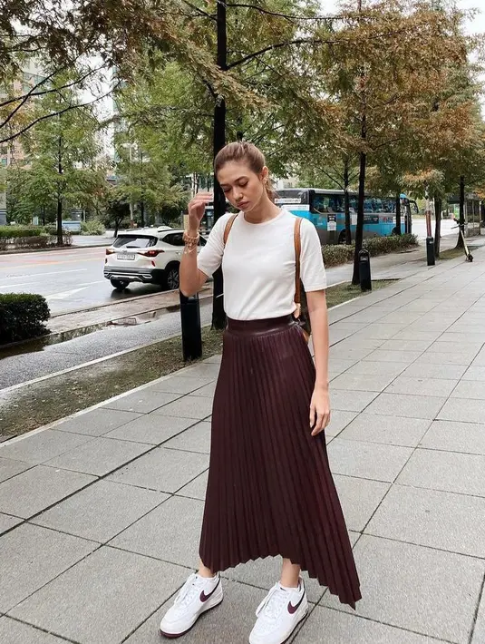 Simple tapi kece, cukup padukan t-shirt polos dengan rok plisket material leather dan sneakers seperti Yuki Kato. (Instagram/yukikt).