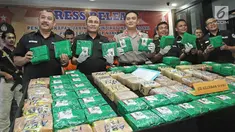 Jajaran DitTipid Narkoba Bareskrim Mabes Polri menunjukkan barang bukti sabu saat rilis di Jakarta, Kamis (21/12). Penyelundupan sabu dari Malaysia menggunakan modus dikemas plastik teh Cina warna kuning dan hijau. (Liputan6.com/Herman Zakharia)