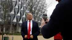Seorang pria mengambil gambar lilin Madame Tussauds Presiden AS Donald Trump yang dipajang di luar Kedutaan Besar AS yang baru di Nine Elms, London (12/1). Donald Trump telah membatalkan rencana kunjungannya ke London. (AP Photo / Alastair Grant)