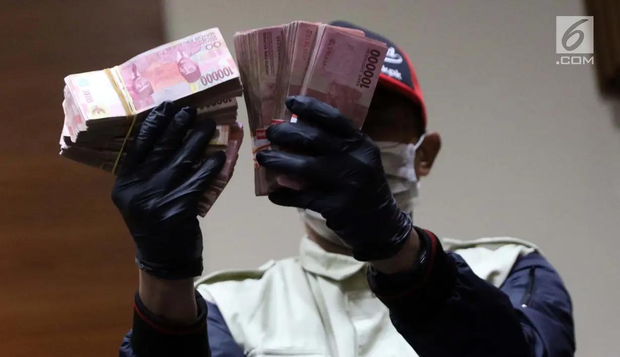 Petugas KPK menunjukkan barang bukti hasil Operasi Tangkap Tangan (OTT) terkait pengisian jabatan perangkat daerah di lingkungan Pemkab Kudus, Gedung KPK Jakarta, Sabtu (27/7/2019). KPK menetapkan tiga tersangka, salah satu diantaranya Bupati Kudus, M Tamzil. (Liputan6.com/Helmi Fithriansyah)