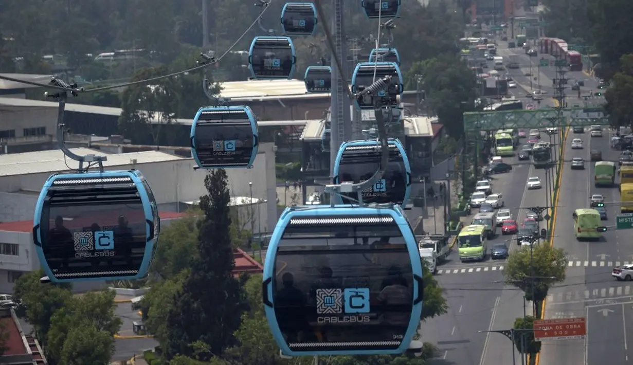Penumpang melakukan perjalanan dengan sistem kereta gantung yang dijuluki Cablebus setelah peresmiannya di pinggiran Mexico City, Meksiko, 12 Juli 2021. Mexico City mulai mengoperasikan sistem kereta gantung yang menjanjikan untuk menghemat waktu bagi ribuan pengguna. (PEDRO PARDO/AFP)