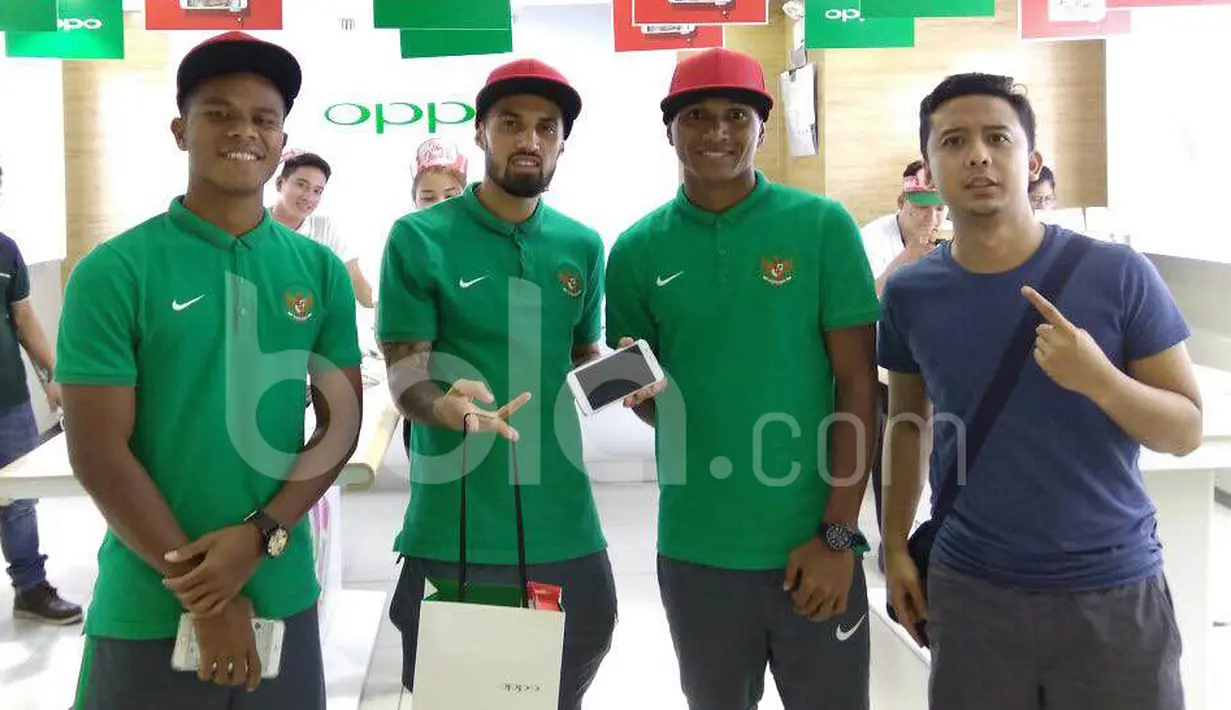 Stefano Lilipaly, M. Abduh Lestaluhu, Manahati Lestusen (kiri), dan seorang staf KBRI Manila berpose dengan telepon seluler barunya di sebuah pusat perbelanjaan di Makati City, Manila, Filipina, Minggu (20/11/2016). (Bola.com/Nicklas Hanoatubun)