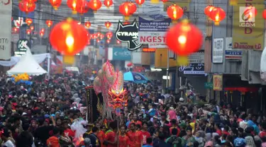 Warga memadati jalan raya saat arak-arakan atraksi liong perayaan Cap Go Meh melewati Jalan Suryakencana, Bogor, Jawa Barat, Selasa (19/2). Acara ini merupakan puncak perayaan Tahun Baru Imlek 2570. (Merdeka.com/Arie Basuki)