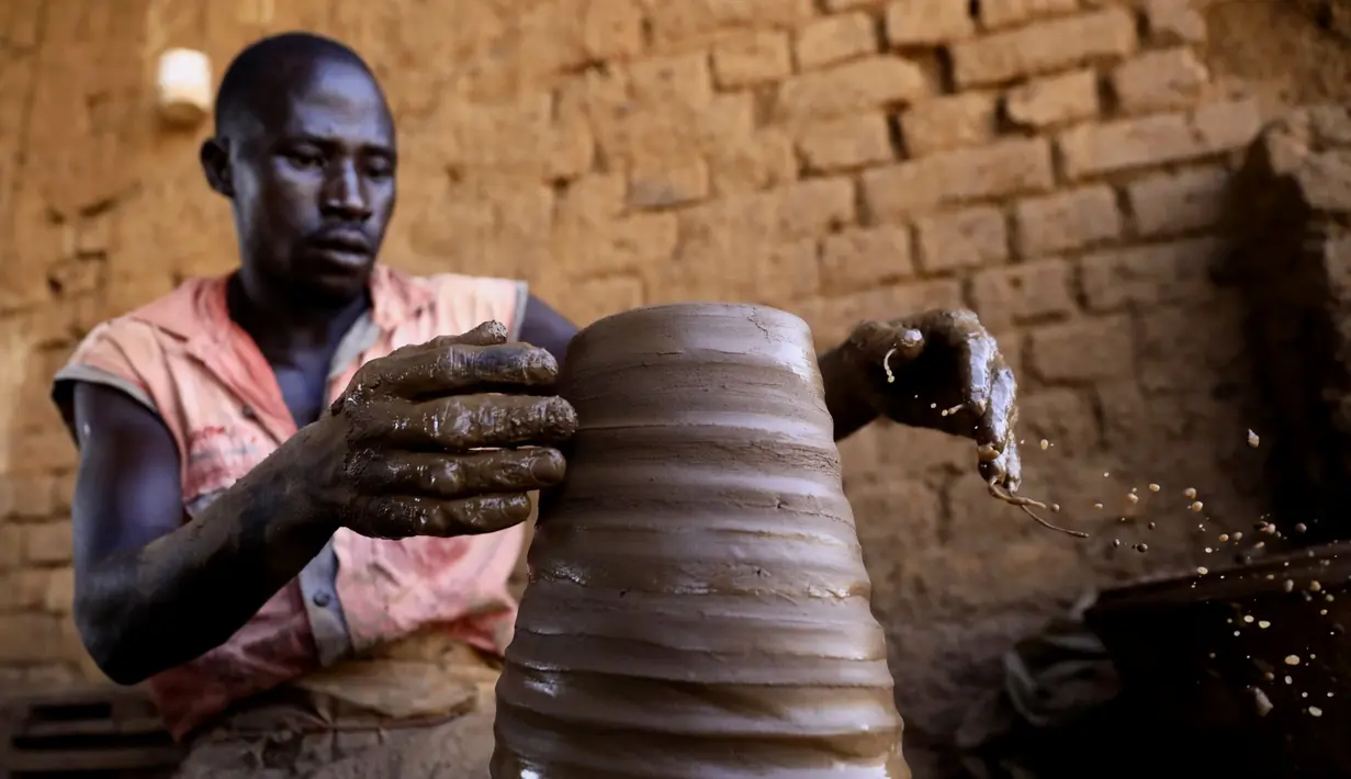 Seorang perajin Sudan membuat tembikar di Khartoum, Sudan (20/10/2020). Para perajin tembikar di Sudan memanfaatkan tanah liat sisa banjir untuk membuat benda-benda kerajinan tersebut. (Xinhua/Mohamed Khidir)