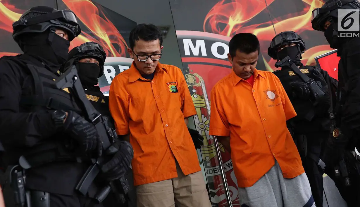 Tersangka pencurian dan pembunuhan sadis terhadap Jeanne Setyadi (78) tertunduk di Polda Metro Jaya, Jakarta, Kamis (26/7). Polisi berhasil menangkap dua tersangka dalam kasus pencurian dan pembunuhan tersebut. (Liputan6.com/Immanuel Antonius)