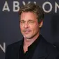 Aktor Brad Pitt berpose untuk fotografer setibanya pada acara premiere film Babylon di Paris, Prancis, 14 Januari 2023. Aktor berusia 59 tahun itu tampak tampan dalam balutan setelan serba hitam. (AP Photo/Michel Euler)
