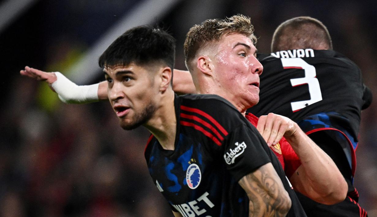 Pemain FC Copenhagen, Kevin Diks, berusaha mengadang pergerakan pemain Manchester United, Rasmus Hojlund,  pada laga Liga Champions di Stadion Old Trafford (24/10/2023). Bek berusia 27 tahun itu tampil tangguh dan disiplin mengawal lini pertahanan. (AFP/Paul ELlis)