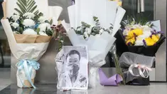 Karangan bunga dan foto mendiang dokter Li Wenliang terlihat di Cabang Houhu Rumah Sakit Pusat Wuhan di Wuhan di provinsi Hubei, China, Jumat, (7/2/2020). Li Wenliang sebelumnya memberikan peringatan kepada publik tentang potensi munculnya virus corona pada Desember 2019. (AFP/STR)