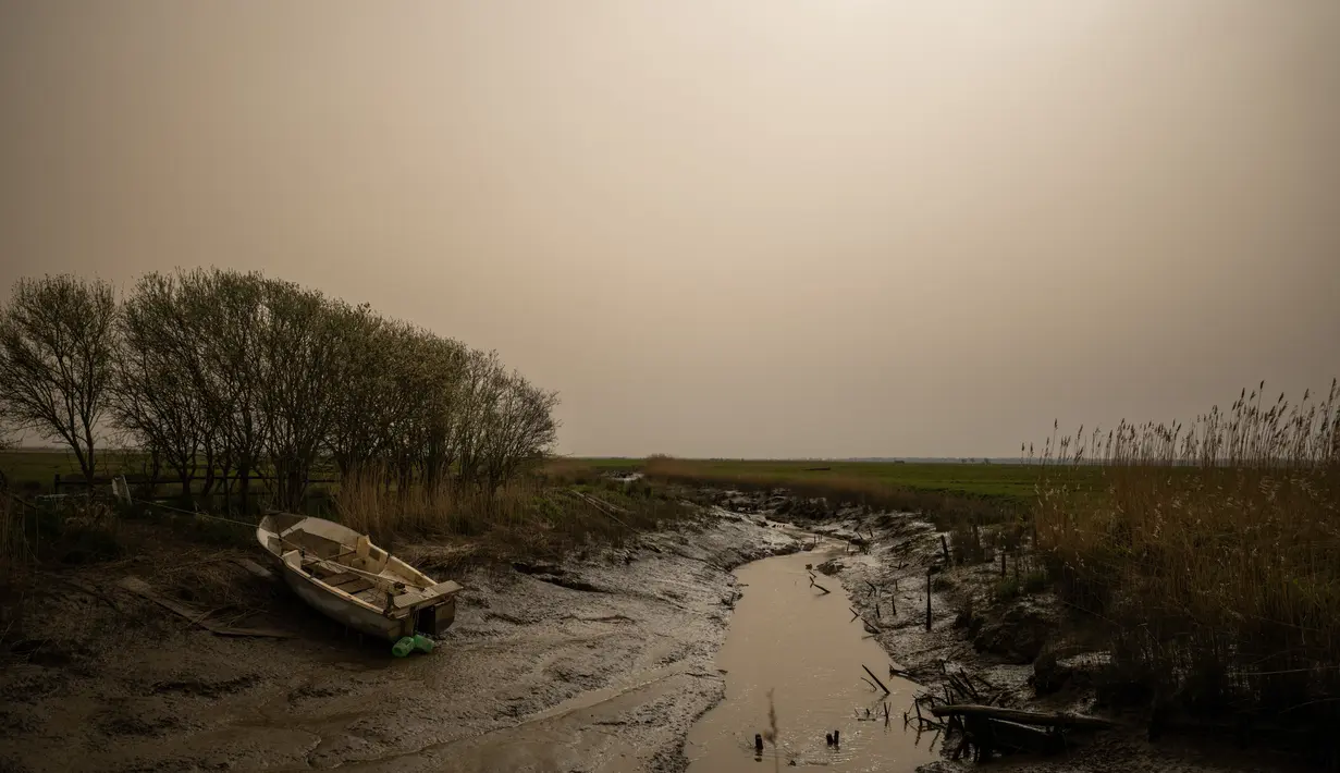 Desa Lavau-sur-Loire ampak diselimuti debu dari gurun Sahara berwarna kuning tua di Prancis barat (15/3/2022). Badai di gurun Sahara menciptakan badai besar hembusan angin, yang mengangkat pasir ke udara. (AFP/Loic Venance)