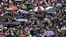Cuaca buruk tak menyurutkan minat warga menyaksikan penobatan Raja Charles III dan Ratu Camilla. (Gareth Fuller/Pool Photo via AP)