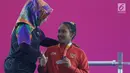 Atlet Para Powerlifting Indonesia, Ni Nengah Widiasih (kanan) saat prosesi medali Womens Up to 41.00kg Asian Para Games 2018 di Jakarta, Minggu (7/10). Ni Nengah Widiasih berhasil melakukan total angkatan 97 kg. (Liputan6.com/Helmi Fithriansyah)