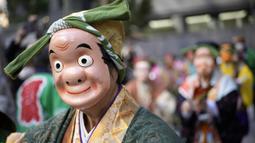 Seniman yang mengenakan topeng badut tradisional Jepang berbaris selama di kuil Kotohiragu di distrik bisnis Toranomon, Tokyo, Selasa (10/1/2023). Selain mengenakan topeng tradisional, para seniman tersebut juga mengenakan pakaian tradisional khas Negeri Matahari Terbit tersebut. (AP Photo/Eugene Hoshiko)