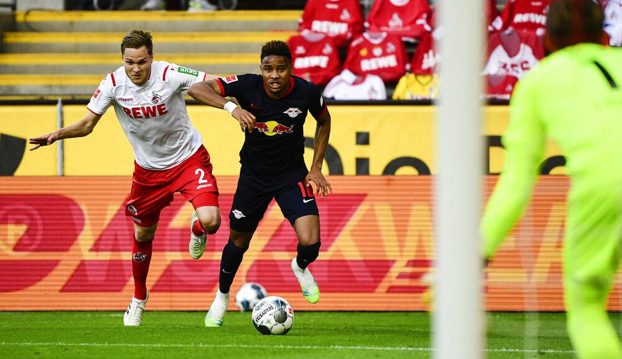Gelandang RB Leipzig, Christopher Nkunku, berebut bola dengan pemain Koln, Benno Schmitz, pada laga Bundesliga di Stadion Rhein Energie, Senin (1/6/2020). RB Leipzig menang dengan skor 4-2. (AP/Ina Fassbender)