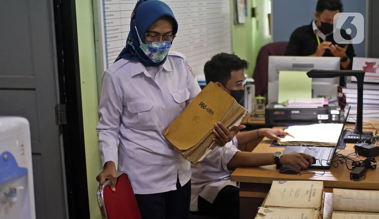 Petugas Dispusip DKI Jakarta mendigitalisasikan arsip sekolah di SMAN 77, Cempaka Putih, Jakarta Pusat, Rabu (24/11/2021). Digitalisasi arsip merupakan upaya alih media atau teknik memindahkan isi atau informasi arsip tercetak, tertulis, atau gambar ke format digital. (Liputan6.com/Herman Zakharia)