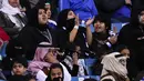 Seorang wanita mendukung tim Al-Hilal dari Saudi saat melawan Al-Ittihad dalam pertandingan Liga Saudi Pro di King Fahd International Stadium di Riyadh (13/1). (AFP Photo/Ali Al-Arifi)