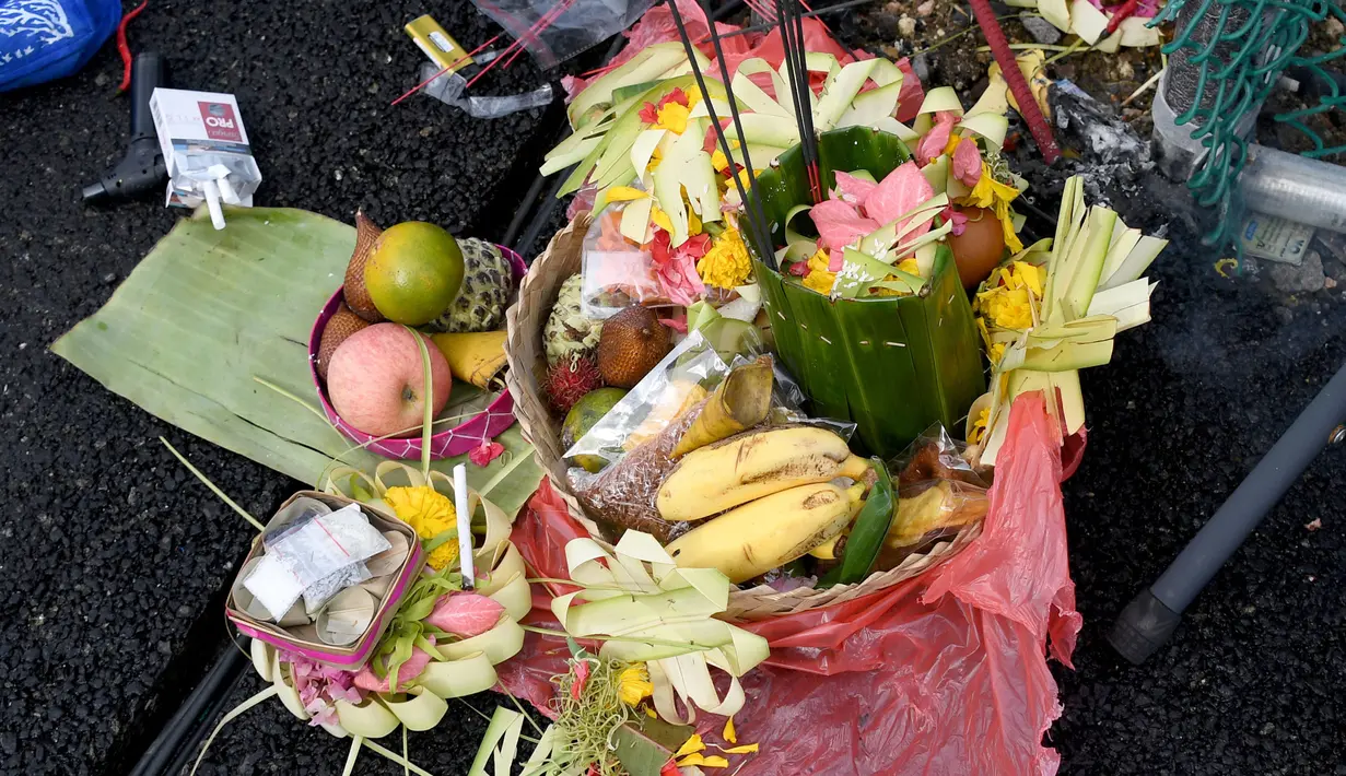 Seorang pawang hujan melakukan ritual saat sesi latihan bebas MotoGP Indonesia di Sirkuit Mandalika, Mandalika, Lombok Tengah, Nusa Tenggara Barat, Jumat (18/3/2022). (AFP/Bay Ismoyo)
