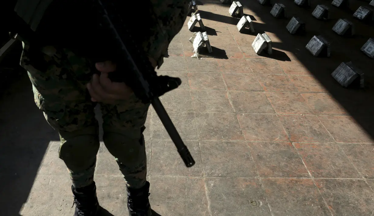 Petugas berjaga di sekitar paket kokain saat menggelar barang bukti narkoba di Panama City, Senin (14/9/2015). Polisi menyita lebih dari 1.145 kg kokain dan mengamankan tiga orang. (REUTERS/Carlos JASSO)