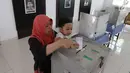 Warga memasukkan surat suara setelah mencoblos pada Pilkada Serentak 2018 di TPS 2 yang berada di dalam Museum Juang Taruna, Tangerang, Rabu (27/6). Warga Kota Tangerang menyalurkan suaranya dalam Pemilihan Walikota tahun ini. (Liputan6.com/Angga Yuniar)