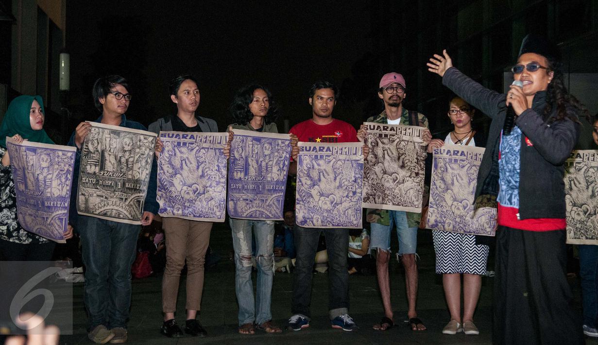 Para simpatisan memegang poster hasil puisi yang digambarkan dari Sastrawan dan Aktivis HAM Widji Thukul, Wahyu Susilo membacakan puisi - puisi karya Widji Thukul di Taman Ismail Marzuki, Jakarta, Selasa (24/1). (Liputan6.com/Gempur M Surya)