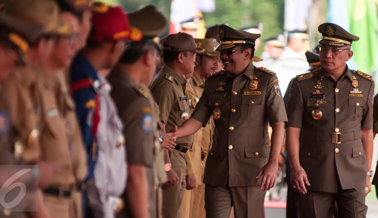 Djarot Saiful Hidayat bersalaman dengan pegawai negri sipil saat upacara hari jadi ke-67 Satpol PP dan ke-55 Satlinmas di Jakarta, Kamis (27/4). Dalam peringatan ini Djarot Saiful Hidayat sebagai inspektur upacara. (Liputan6.com/Gempur M. Surya)