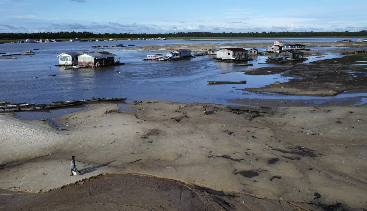 Seorang wanita berjalan di daerah yang terkena dampak kekeringan dekat Sungai Solimões, Tefe, Amazonas, Brasil, Rabu (19/10/2022). Ribuan keluarga mengalami banjir yang menghancurkan tanaman dan kini menghadapi masalah parah kekeringan yang telah terjadi berbulan-bulan. (AP Photo/Edmar Barros)
