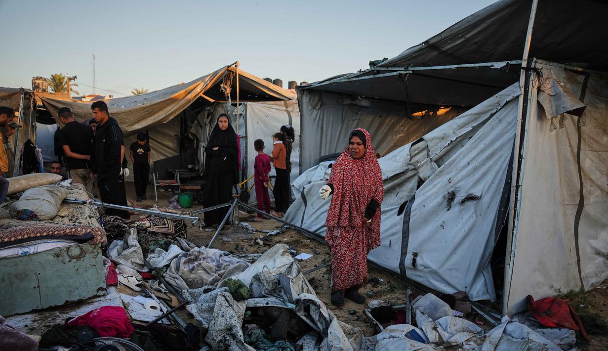 Warga Palestina yang mengungsi memeriksa kerusakan akibat serangan tentara Israel di kamp tenda mereka di Deir al-Balah, Jalur Gaza, Rabu 29 Oktober 2025. Serangan udara Israel ini melanggar kesepakatan gencatan senjata yang dimediasi oleh Amerika Serikat pada 10 Oktober 2025 lalu. (AP Photo/Abdel Kareem Hana)