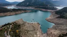 Foto ini menunjukkan sisa-sisa rumah yang muncul kembali ketika permukaan danau buatan Mornos menurun akibat kekeringan, di desa Kallio, sekitar 240 km barat laut Athena, Yunani pada 3 November 2025. Sebuah desa yang sudah tenggelam muncul kembali di Danau Mornos, Yunani pada 3 November 2025. (Angelos TZORTZINIS/AFP)