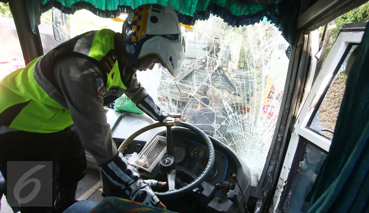Petugas kepolisian menyelidiki sebuah bus PO Merdeka yang menabrak pohon di jalur Lingkar, Jawa Barat, Sabtu (2/7). Kecelakaan terjadi karena rem bus bernopol Z 7829 T itu tidak berfungsi, alias blong. (Liputan6.com/Immanuel Antonius)