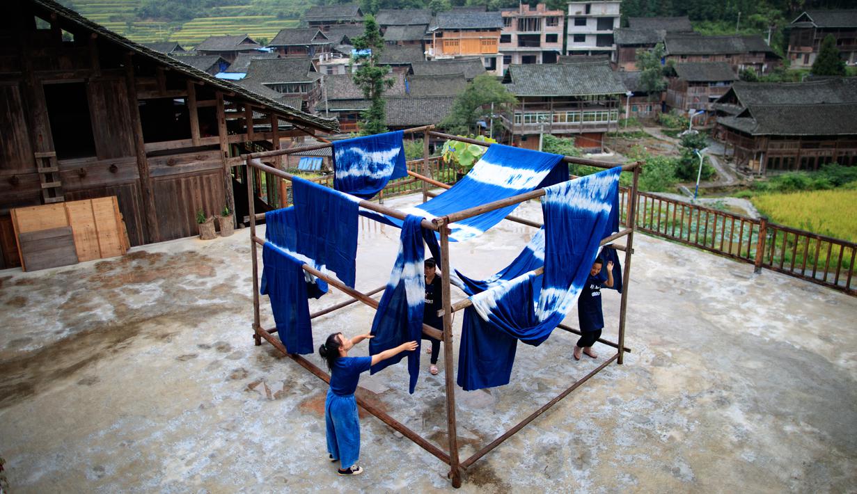 Sejumlah perempuan menjemur kain di sebuah bengkel kerja di Desa Etnis Dong Fengdeng di Wilayah Rongjiang, Provinsi Guizhou, China pada 6 September 2020. Warga setempat memanfaatkan kondisi cuaca musim gugur yang mendukung untuk membuat kain tradisional kelompok etnis Dong. (Xinhua/Liu Xu)