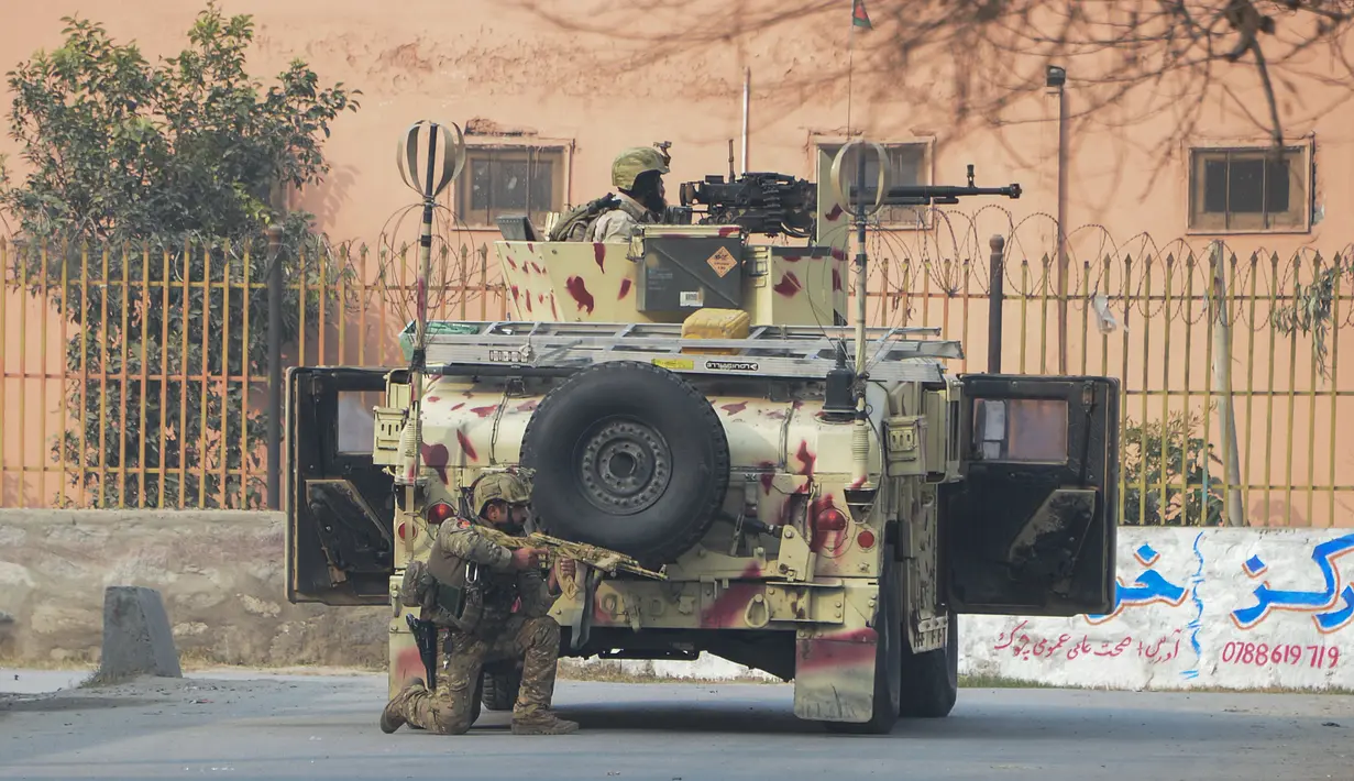 Tentara Afghanistan bersiap siaga di dekat kantor amal Inggris Save the Children saat terjadi serangan yang sedang berlangsung di Jalalabad, Afghanistan (24/1). (AFP Photo/Noorullah Shirzada)