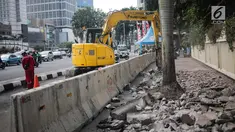 Pekerja dibantu alat berat merevitalisasi trotoar di kawasan Bundaran HI, Jakarta Pusat, Senin (15/7/2019). Penantaan ini dilakukan untuk mempercantik trotoar dan memberikan rasa nyaman bagi pejalan kaki. (Liputan6.com/Faizal Fanani)