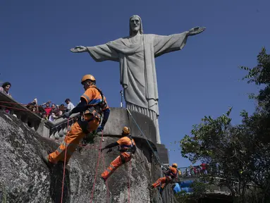 Para pembersih sampah menuruni Gunung Corcovado untuk membuang sampah yang dibuang di lereng Patung Kristus Penebus di Rio de Janeiro, Brasil pada Kamis, 22 Agustus 2024. (AP Photo/Bruna Prado)