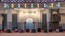 Petugas masjid mendengarkan khotbah salat Jumat dengan menerapkan jaga jarak aman saat Ramadan di Masjid Negara Malaysia, Kuala Lumpur, Malaysia, Jumat (15/5/2020). Masjid Negara Malaysia kembali dibuka setelah pemerintah setempat melonggarkan lockdown akibat pandemi COVID-19. (Mohd RASFAN/AFP)