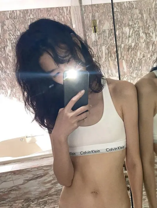 Saat menjadi mengenakan bra sport Calvin Klein warna putih, ia juga tampak memerlihatkan lengan dan perutnya yang begitu langsing.